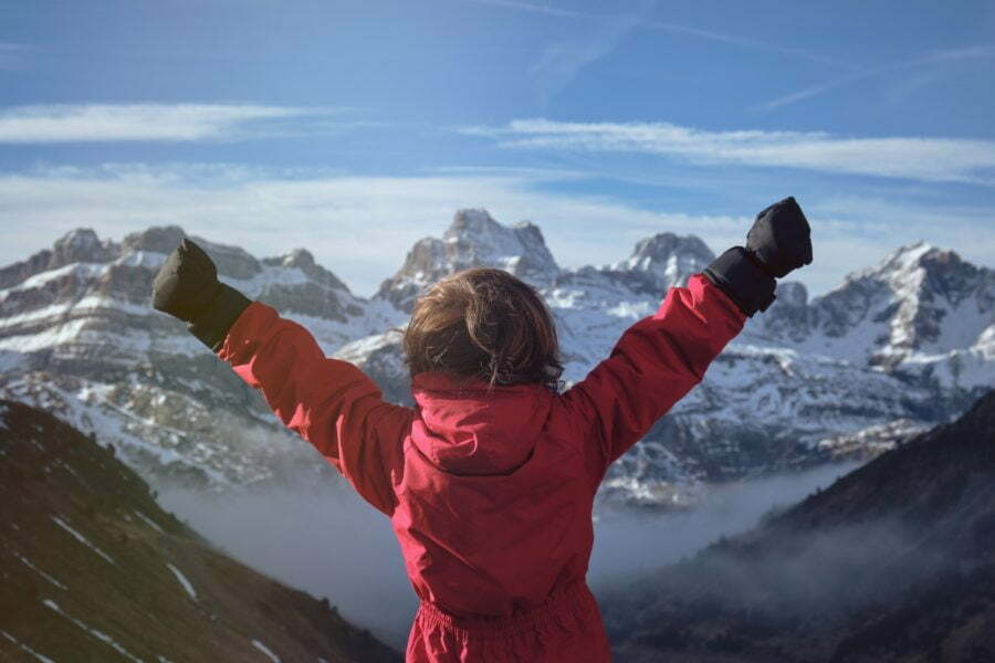 Anonymous kid celebrating success in mountains What Actually Leads To Success?